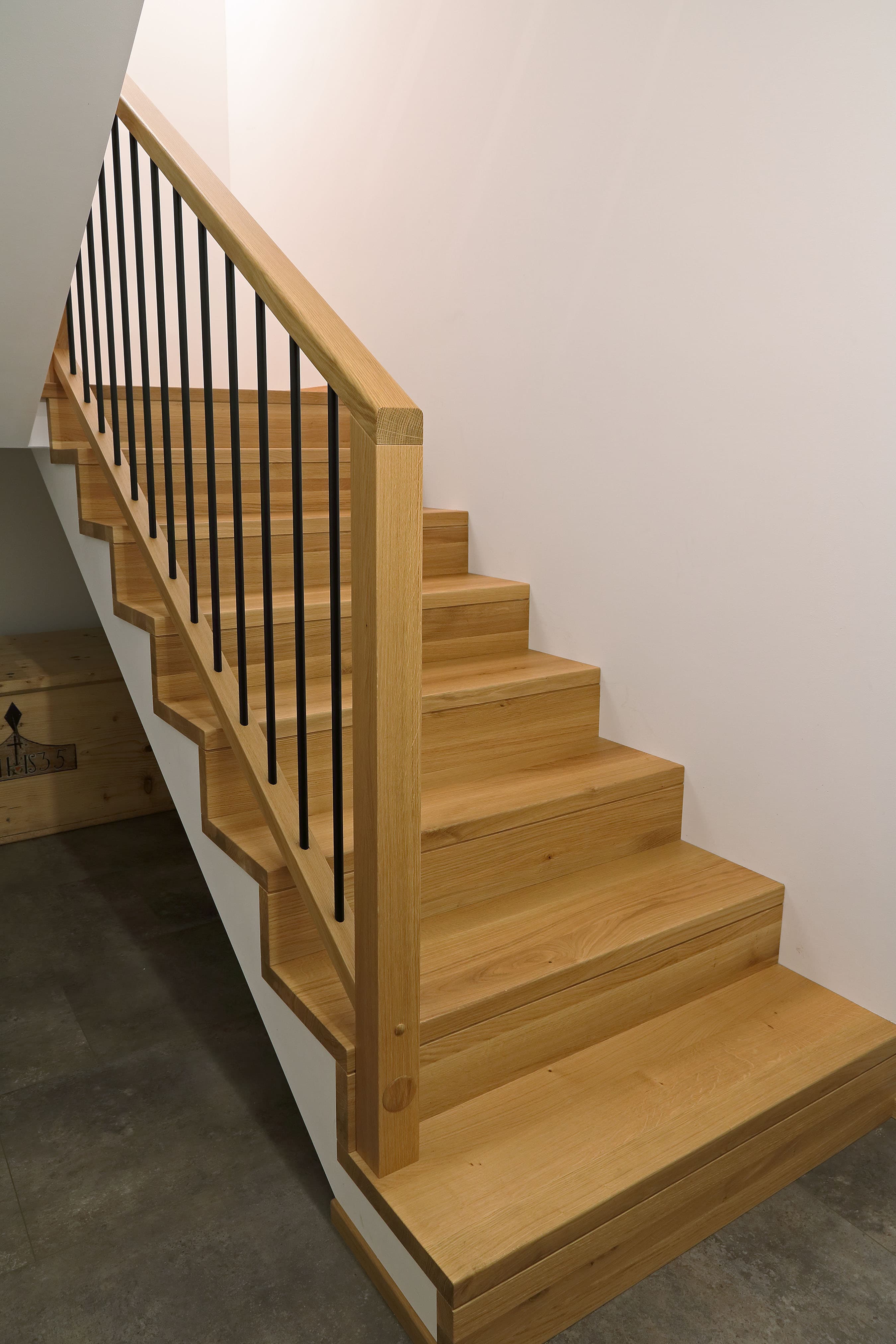 Minimalist Holztreppe mit schwarzen Metallstäben