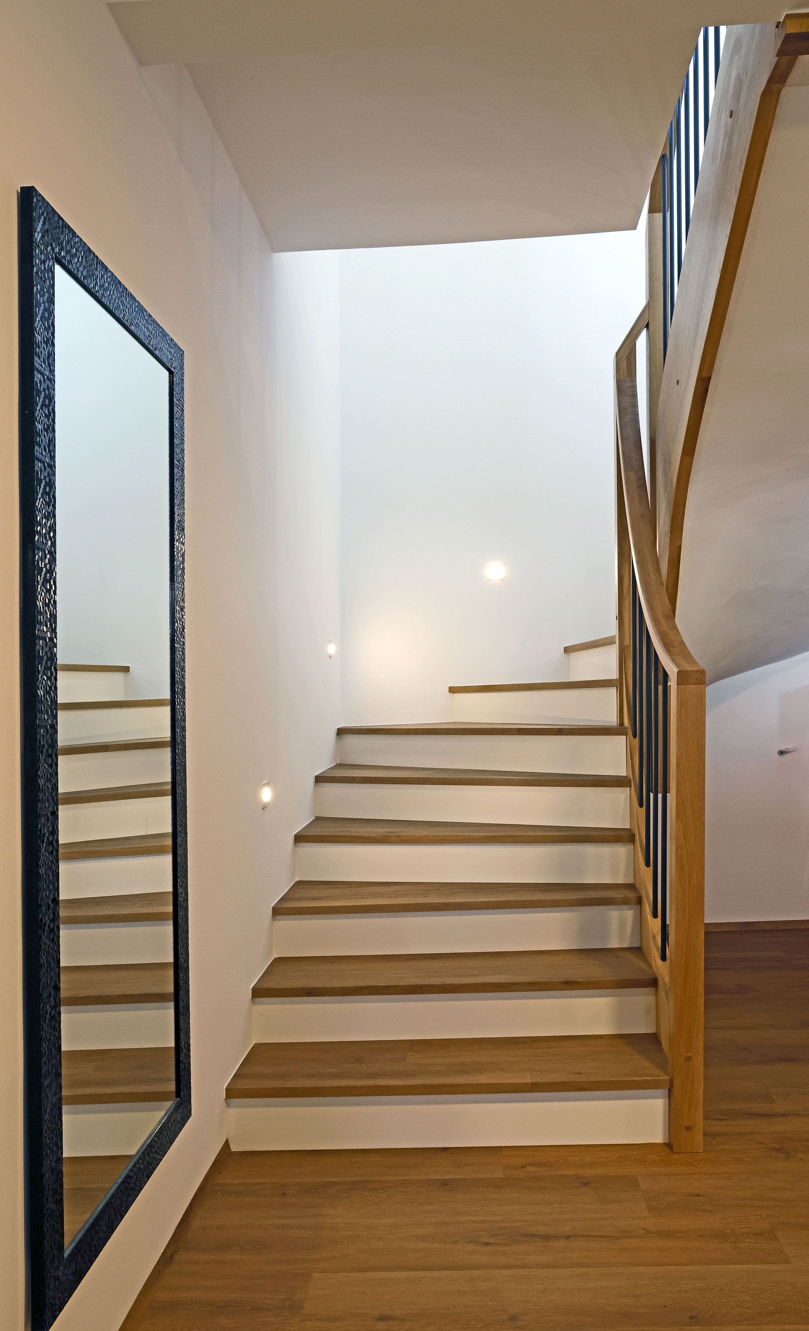 Geschwungene Betonstiege mit Holzauftritten und Holzgeländer - Bild 1