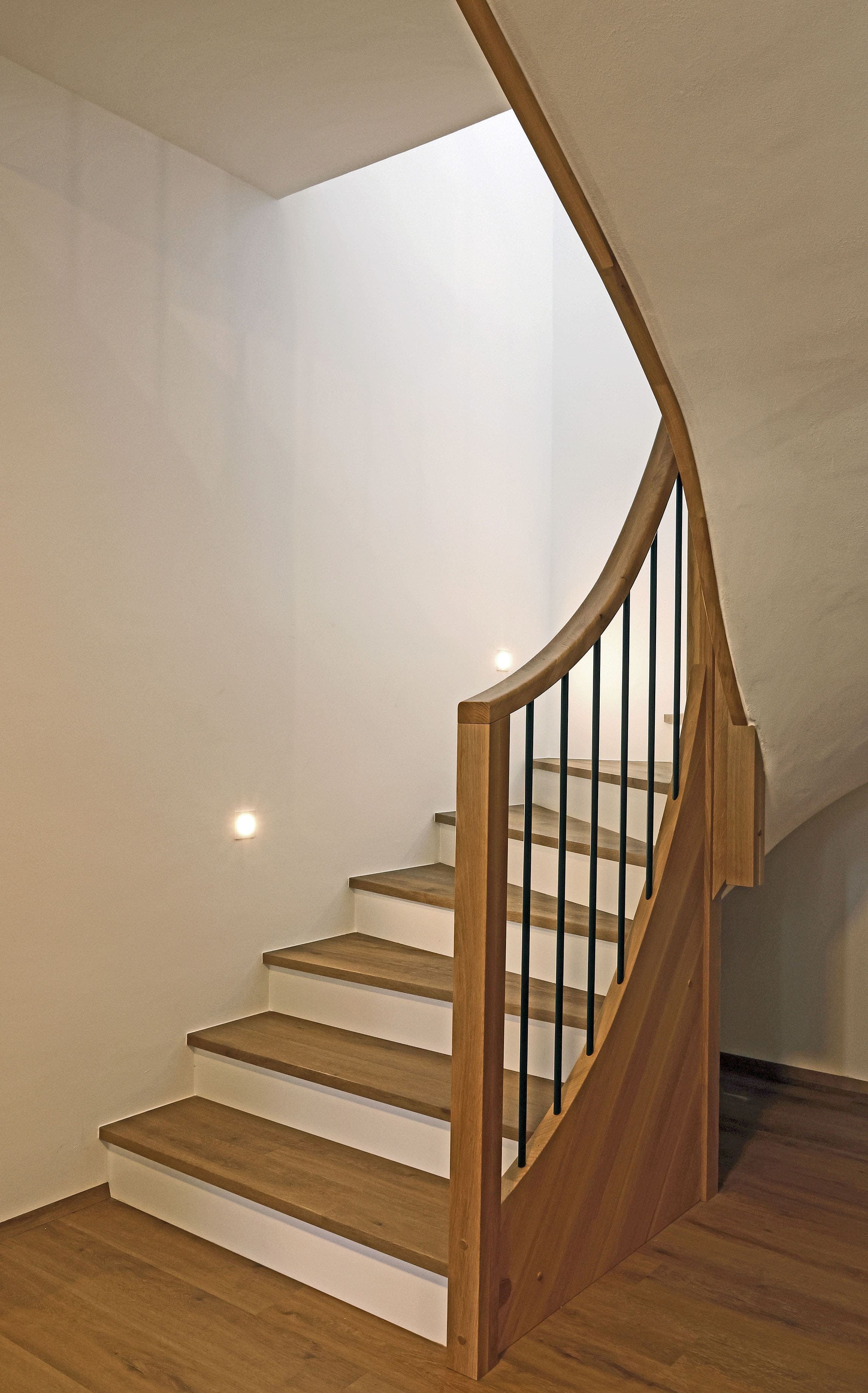 Geschwungene Betonstiege mit Holzauftritten und Holzgeländer - Bild 2