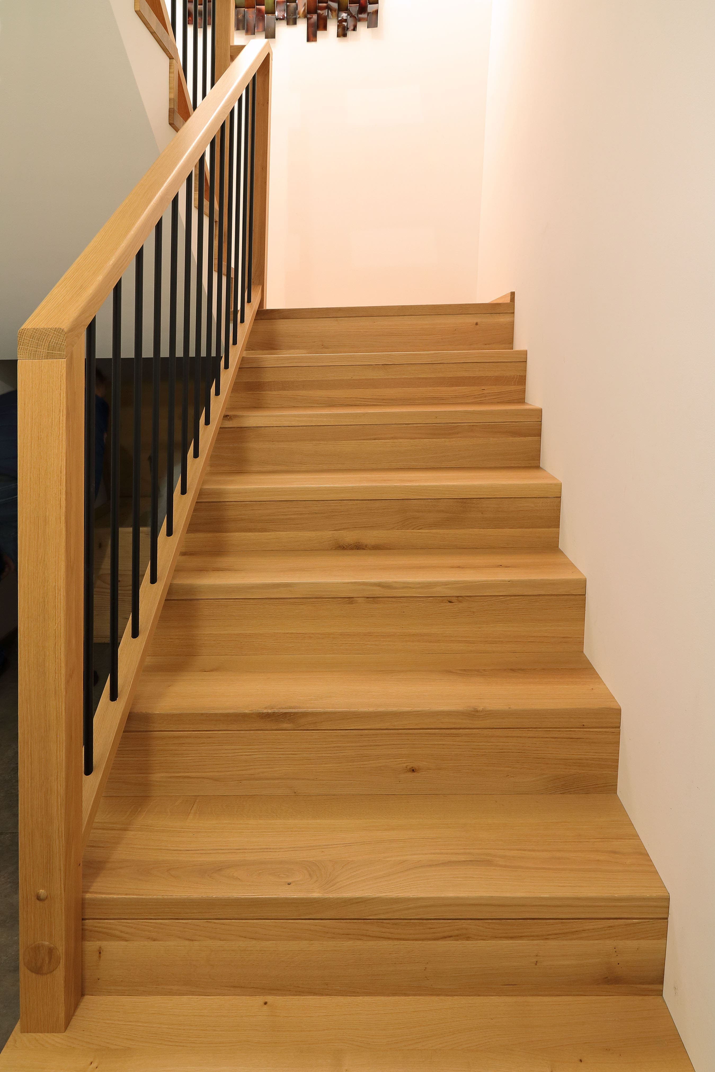 Moderne Betonstiege mit Holzauftritt und schwarzem Geländer - Bild 1