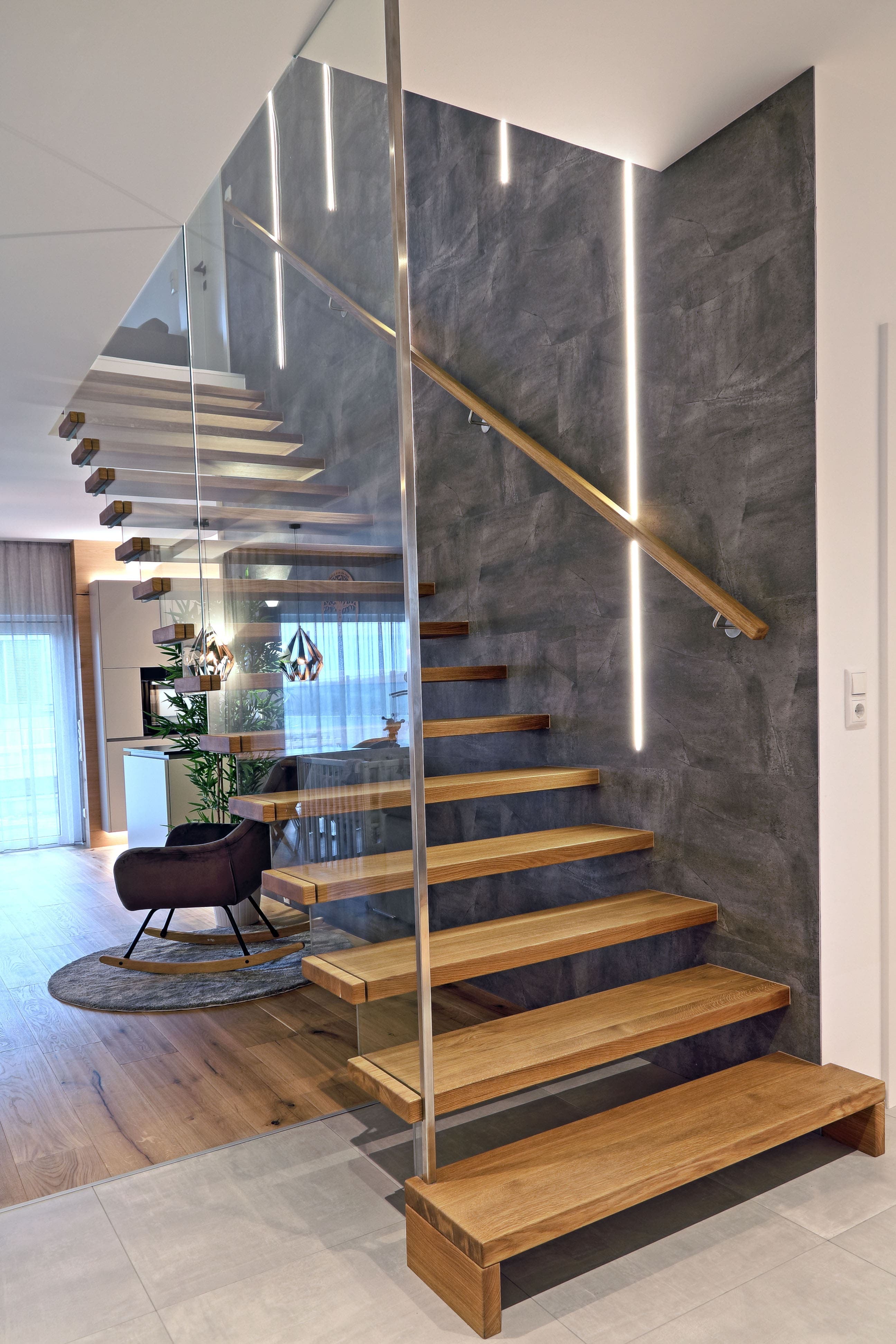 Moderne freitragende Holztreppe mit Glasgeländer und Lichtakzenten - Bild 1