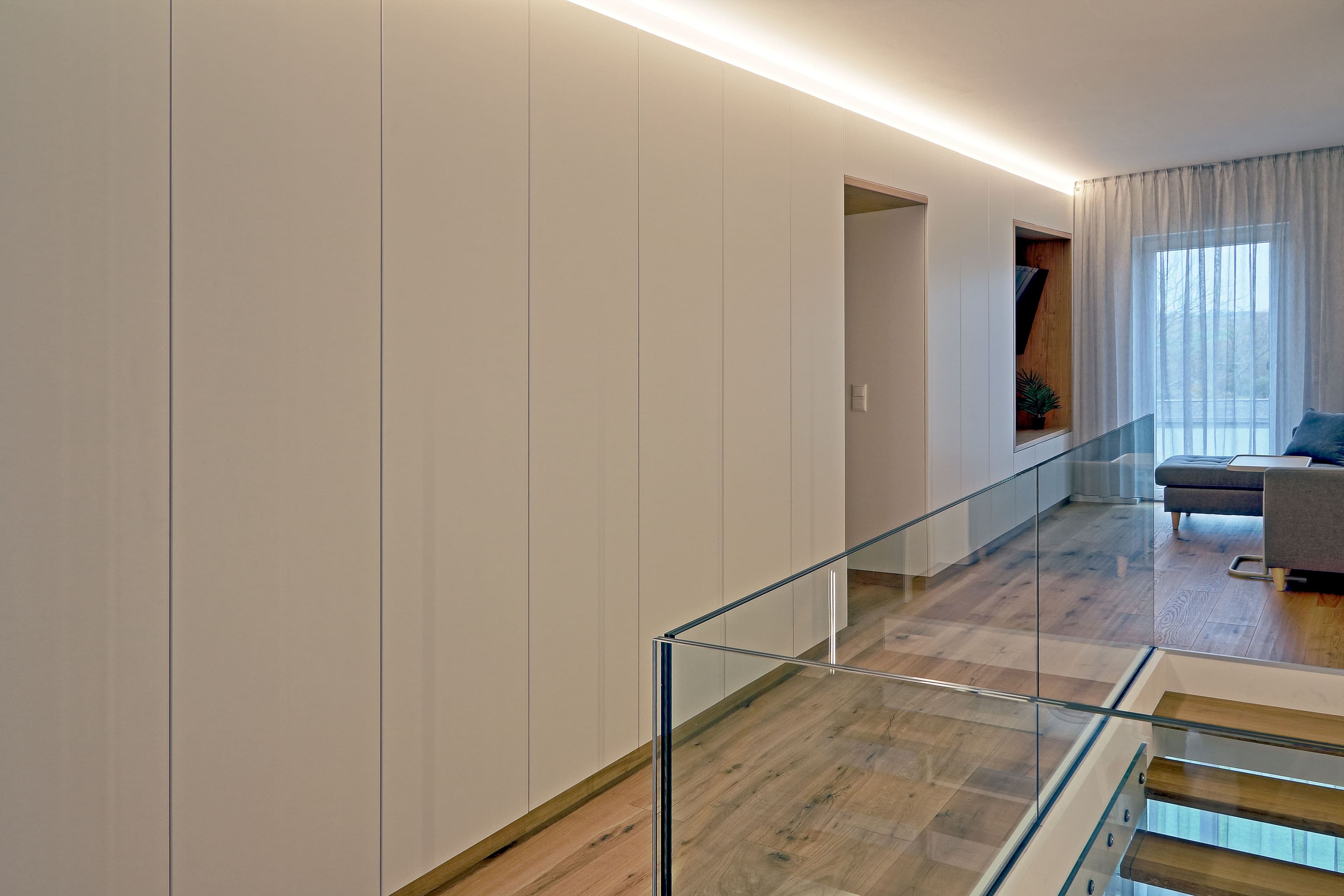 Moderne freitragende Holztreppe mit Glasgeländer und Lichtakzenten - Bild 6