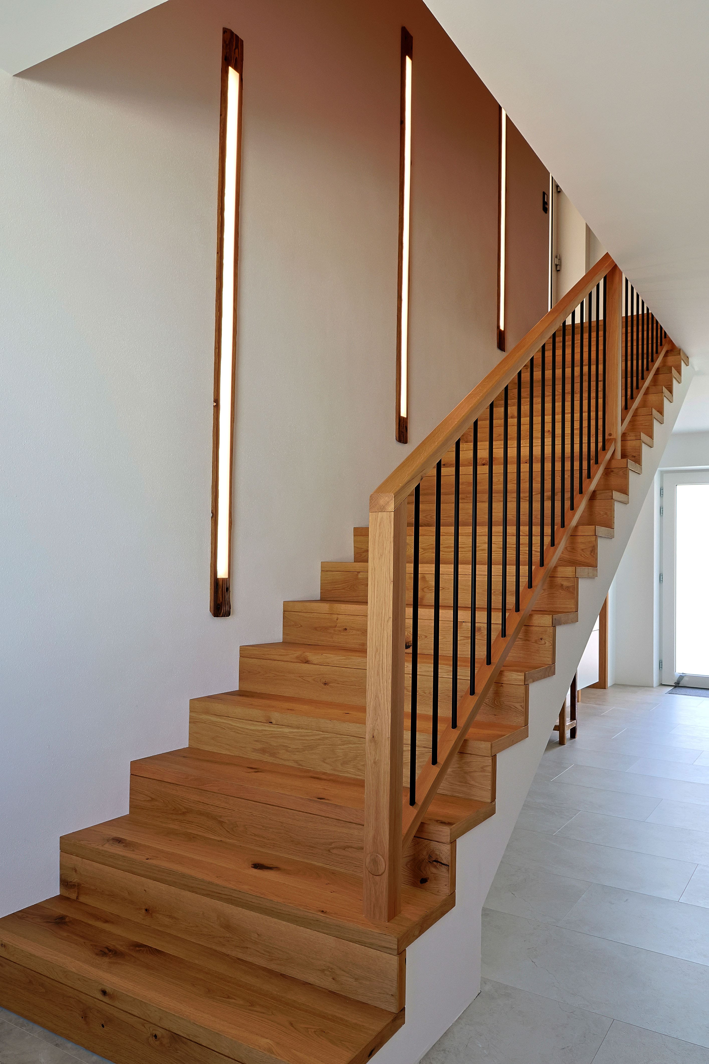 Betonstiege mit Eichenstufen und Metallstäbchen