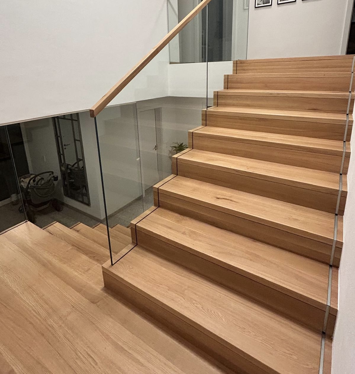 Betonstiege mit Glasgeländer und Holzhandlauf