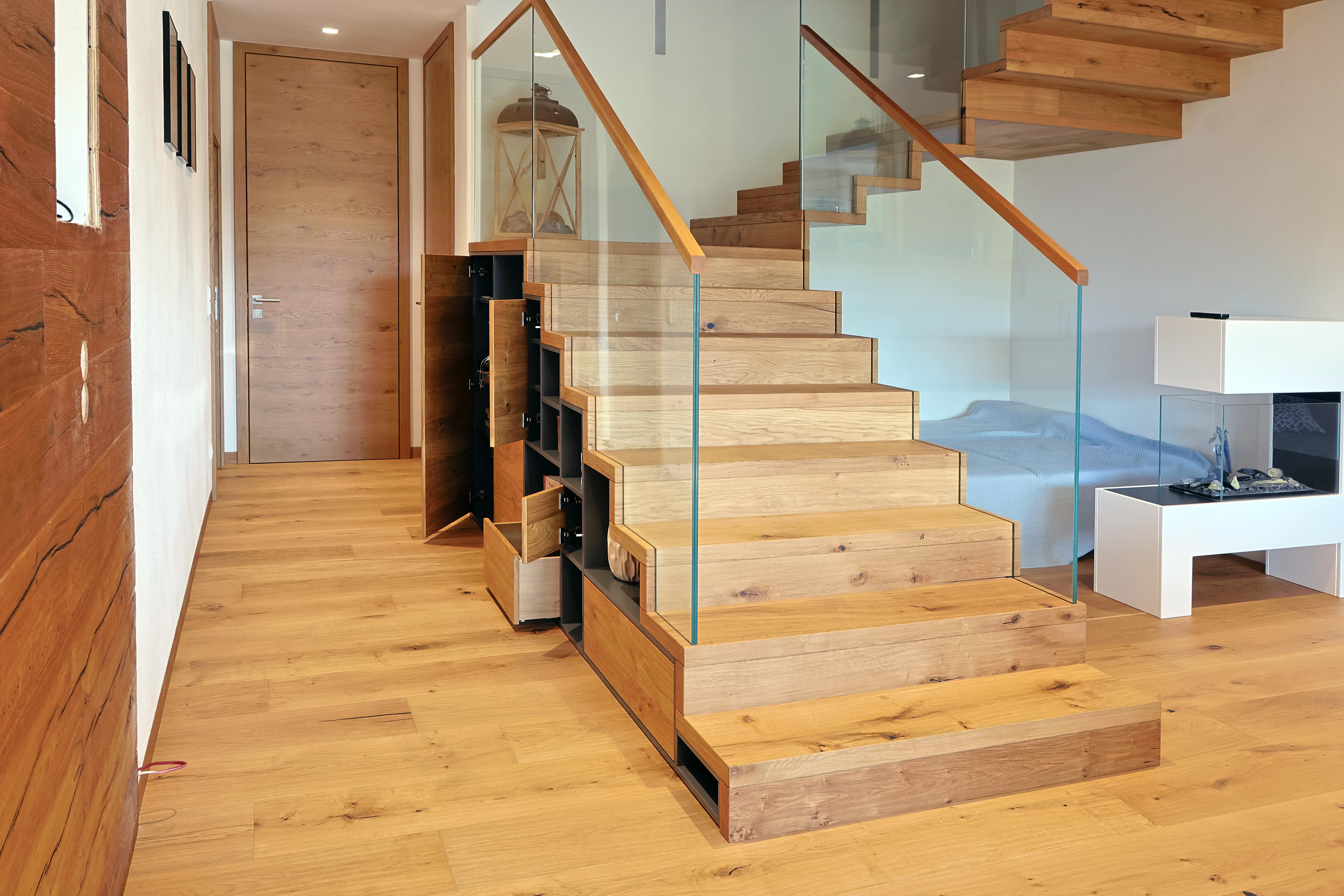Holztreppe mit Glasgeländer und Stauraum